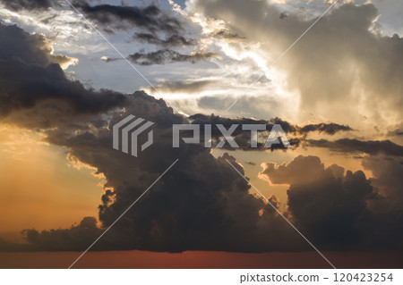 Beautiful sunset sky scenery. Bright colorful orange and yellow clouds on horizon 120423254