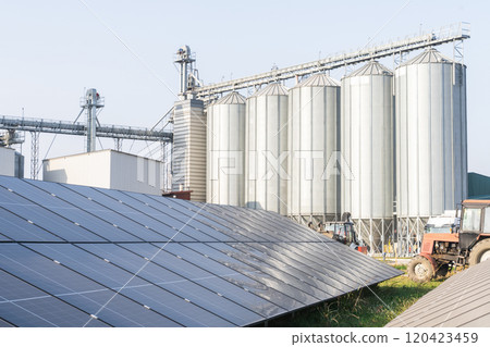 Modern farm using renewable energy. Solar panels with silos in the background. Modern farm using renewable energy. Solar panels with silos in the background. 120423459
