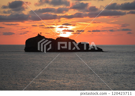 View of the sun setting over Okinoshima Island from Shirato Beach in summer in Tottori Prefecture View of the sun setting over Okinoshima Island from Shirato Beach in summer in Tottori Prefecture 120423711