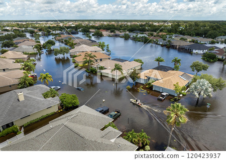 Aftermath of hurricane Debby flooding natural disaster. Boat floating on flooded street surrounded by tropical storm rainfall flood waters homes in Sarasota, Florida residential area 120423937