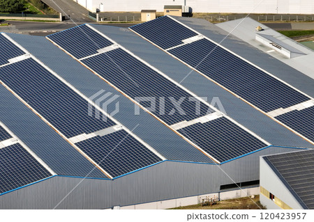 Aerial view of solar power plant with blue photovoltaic panels mounted on industrial building roof for producing green ecological electricity. Production of sustainable energy concept Aerial view of solar power plant with blue photovoltaic panels mounted on industrial building roof for producing green ecological electricity. Production of sustainable energy concept 120423957