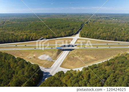 Aerial view of freeway overpass junction with fast moving traffic cars and trucks in american rural area. Interstate transportation infrastructure in USA Aerial view of freeway overpass junction with fast moving traffic cars and trucks in american rural area. Interstate transportation infrastructure in USA 120424025