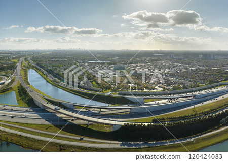 Aerial view of american highway junction with fast driving vehicles in Miami, Florida. View from above of USA transportation infrastructure Aerial view of american highway junction with fast driving vehicles in Miami, Florida. View from above of USA transportation infrastructure 120424083