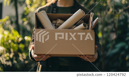 Hands carrying a brown box filled with used paper for recycling. Highlights the importance of paper recycling in conserving natural resources and reducing waste. Hands carrying a brown box filled with used paper for recycling. Highlights the importance of paper recycling in conserving natural resources and reducing waste. 120424792