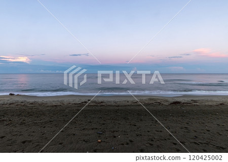 Serene beach at sunset with soft pink skies and sandy shore in evening light Serene beach at sunset with soft pink skies and sandy shore in evening light 120425002