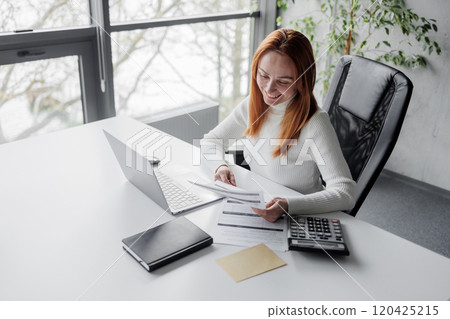 Businesswoman Analyzing Financial Documents in Modern Office 120425215