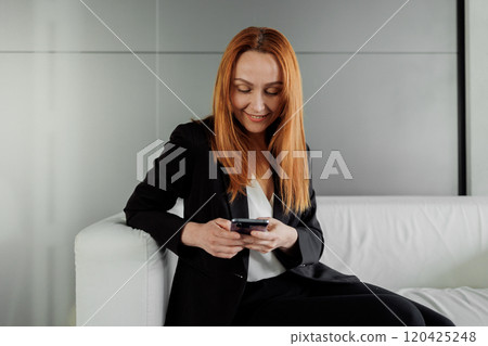 Woman Using Smartphone on Couch 120425248