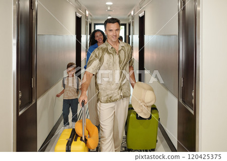 Family Enjoying Vacation While Moving Luggage in Hotel Hallway Family Enjoying Vacation While Moving Luggage in Hotel Hallway 120425375