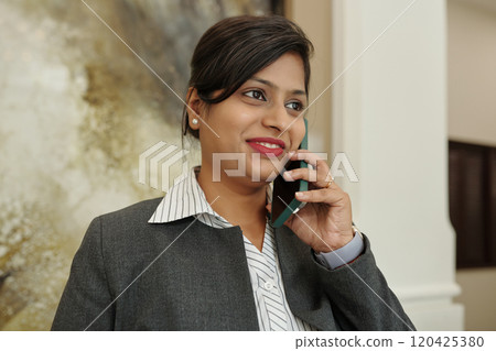 Smiling Woman Talking on Phone in Office Environment 120425380