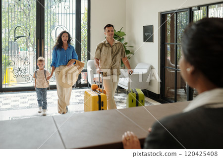 Family Checking into Hotel Lobby with Luggage 120425408