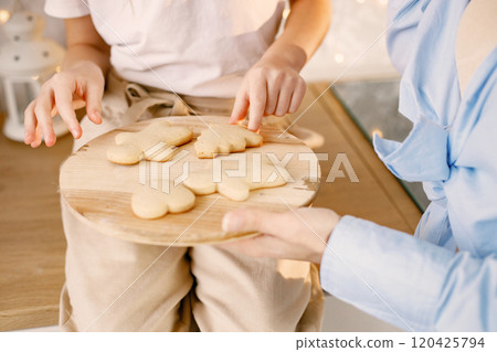 Cropped photo of a wooden tray with a homemade cookies. Family preparation holiday food. Mother and daughter cooking cookies. 120425794