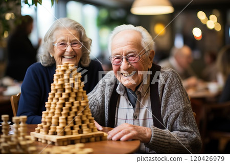 A man and a woman in a nursing home are playing a board game. A man and a woman in a nursing home are playing a board game. 120426979