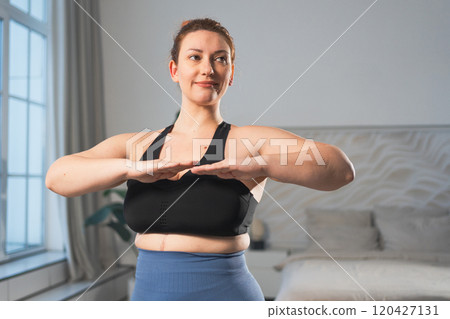 Fitness workout training. Woman practicing fitness at home. Plus size female doing sports exercise at home indoor. Girl in sportswear have workout weight training for weight loss. Sport and fitness 120427131
