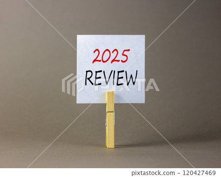 Planning 2025 review new year symbol. Concept words 2025 Review on beautiful white paper on wooden clothespin. Beautiful grey background. Business 2025 review new year concept. Copy space. 120427469