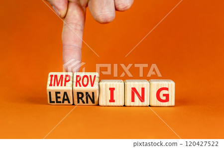 Improving or learning symbol. Businessman turns wooden cubes and changes the word Improving to Learning . Beautiful orange background. Educational business improving or learning concept. Copy space. 120427522