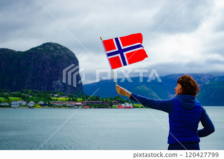 Tourist with norwegian flag on fjord Tourist with norwegian flag on fjord 120427799