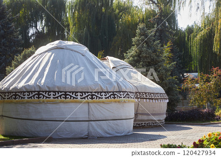 Two yurts surrounded by lush foliage of trees, stand in Bishkek city park Two yurts surrounded by lush foliage of trees, stand in Bishkek city park 120427934