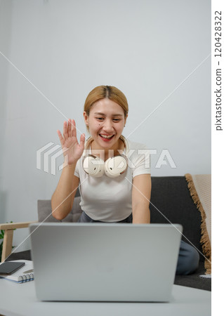 A woman wearing headphones is smiling 120428322