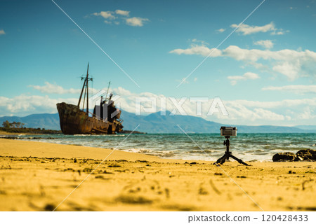 Camera on tripod and shipwreck Camera on tripod and shipwreck 120428433