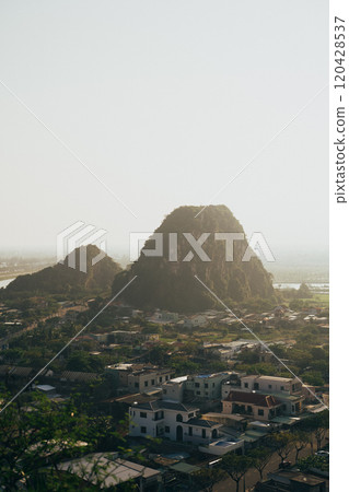 Aerial view of lush greenery and rocky hills surrounding Da Nang, Vietnam during a hazy afternoon Aerial view of lush greenery and rocky hills surrounding Da Nang, Vietnam during a hazy afternoon 120428537