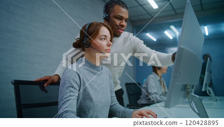 Team of technical support specialists discuss work monitoring data on computer 120428895