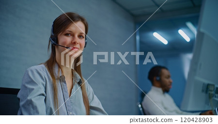 Call center: Close up of positive female helpdesk specialist looking at camera 120428903