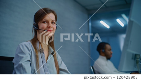 Call center: Close up of positive female helpdesk specialist looking at camera 120428905