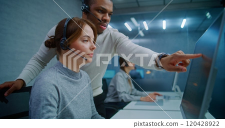 Team of technical support specialists discuss work monitoring data on computer Team of technical support specialists discuss work monitoring data on computer 120428922