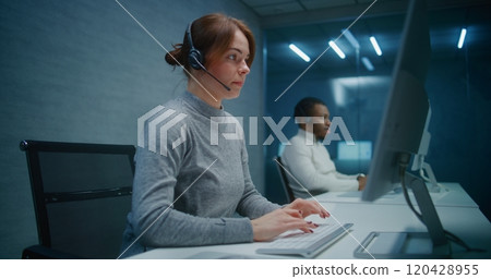 Female technical support specialist wears headset, starts night shift in call center Female technical support specialist wears headset, starts night shift in call center 120428955