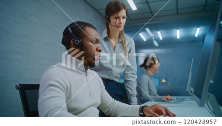African American technical support specialist monitors data on computer with colleague African American technical support specialist monitors data on computer with colleague 120428957