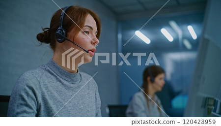 Positive female helpdesk specialist talking on headset, providing online assistance Positive female helpdesk specialist talking on headset, providing online assistance 120428959
