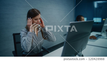 Female hotline operator wears headset, starts night shift providing online customer service 120428988