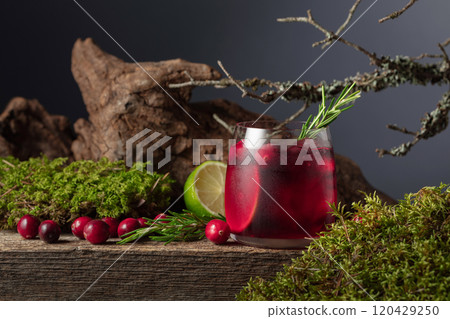 Cranberry cocktail with ice, lime, and rosemary on a old wooden board. Cranberry cocktail with ice, lime, and rosemary on a old wooden board. 120429250