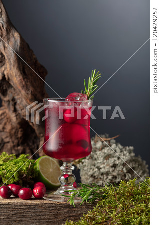 Cranberry cocktail with ice, lime, and rosemary on a old wooden board. Cranberry cocktail with ice, lime, and rosemary on a old wooden board. 120429252