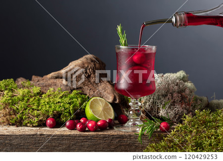 Cranberry cocktail with ice, lime, and rosemary on a old wooden board. Cranberry cocktail with ice, lime, and rosemary on a old wooden board. 120429253
