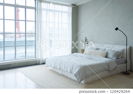 Stylish loft bedroom interior. Spacious design apartment with light walls large windows big bed. Clean modern decoration with elegant furniture in minimalist Scandinavian style Stylish loft bedroom interior. Spacious design apartment with light walls large windows big bed. Clean modern decoration with elegant furniture in minimalist Scandinavian style 120429264