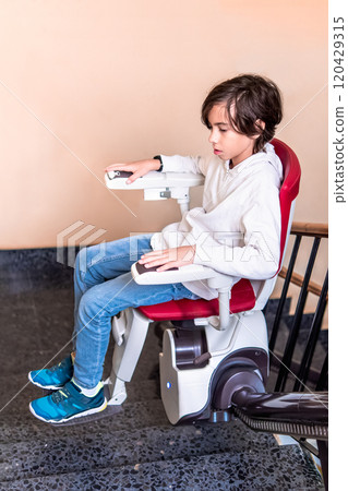 Child Using Stairlift on Indoor Staircase Child Using Stairlift on Indoor Staircase 120429315