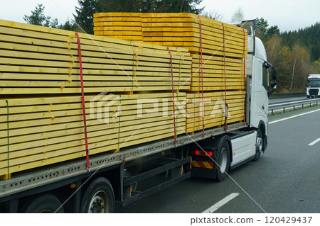 A truck transports lumber - boards on a motorway on a semi-trailer. 120429437