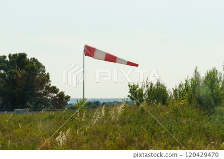 A red and white wind cone indicating the direction and strength of the wind 120429470