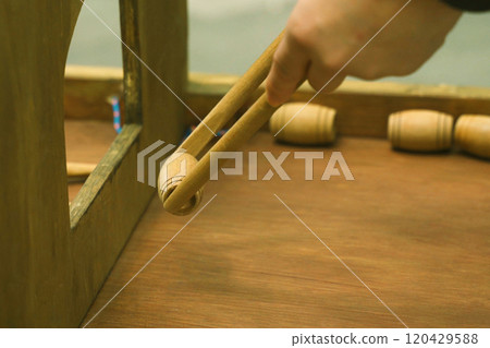 The child plays a board game, throwing kegs with sticks through the window to another field. The child plays a board game, throwing kegs with sticks through the window to another field. 120429588