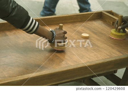 African teenagers play air hockey on the street, close-up of hands African teenagers play air hockey on the street, close-up of hands 120429608