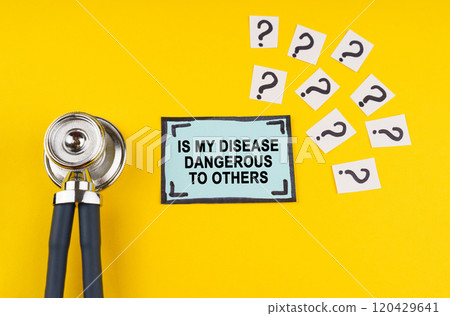 On a yellow background, a stethoscope and a sticker with the inscription - Is my disease dangerous to others 120429641