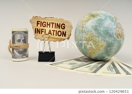On the table are dollars, a globe and there is a sign with the inscription - Fighting inflation 120429651