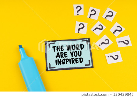 On the yellow surface is a marker, question marks and a sticker with the inscription - THE WORD ARE YOU INSPIRED 120429845