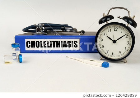 On a white surface, a thermometer, a stethoscope and a folder with the inscription - Cholelithiasis 120429859