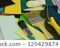 A paintbrush is placed on top of a high stack of paint samples 120429874