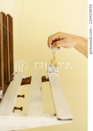 Person renovating wooden hanger 120429950
