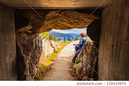 Tourist on Vedahaugane cave entrance, Norway 120429979