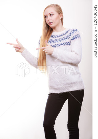 Teenage blonde woman pointing at copyspace Teenage blonde woman pointing at copyspace 120430045