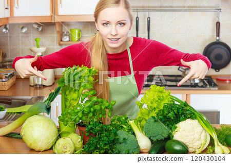 Woman in kitchen having many green vegetables Woman in kitchen having many green vegetables 120430104